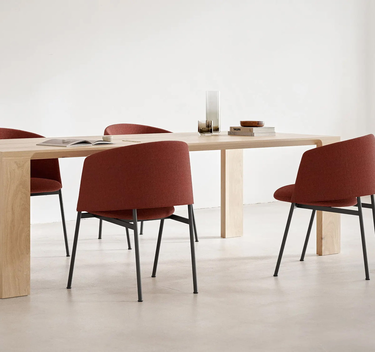 ergoform von Scheschy GmbH Ein Esstisch aus Holz mit vier roten Sesseln