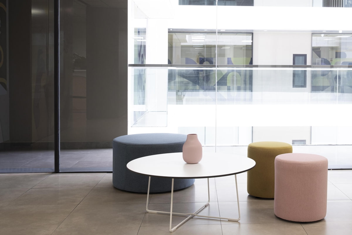 ergoform von Scheschy GmbH Drei Hocker und ein runder Tisch mit Vase