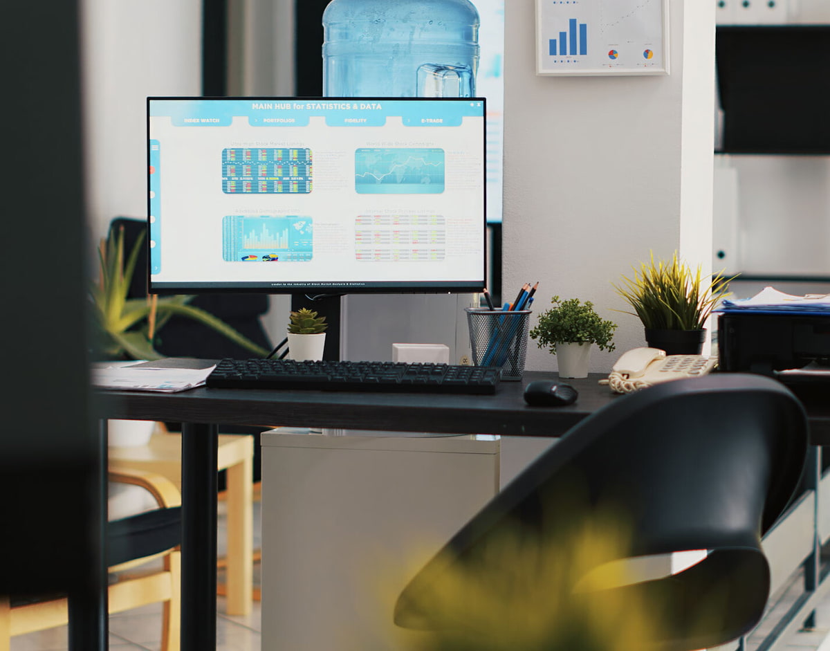 ergoform von Scheschy GmbH Ein großer Bürotisch mit Bildschirm, Tastatur, Maus, Drucker und Schreibutensilien